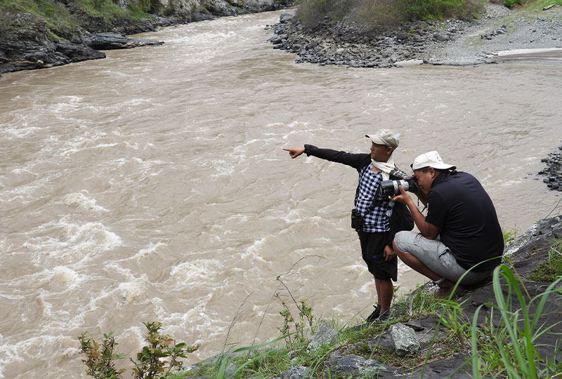 two people standing by the river and pointing