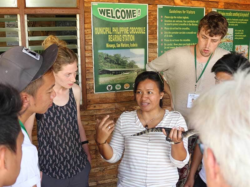 A group of people listening to a woman speaking.