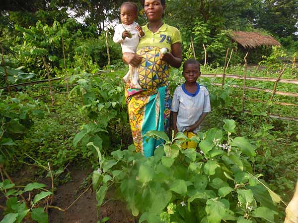 a parent and two children standing in vegetation