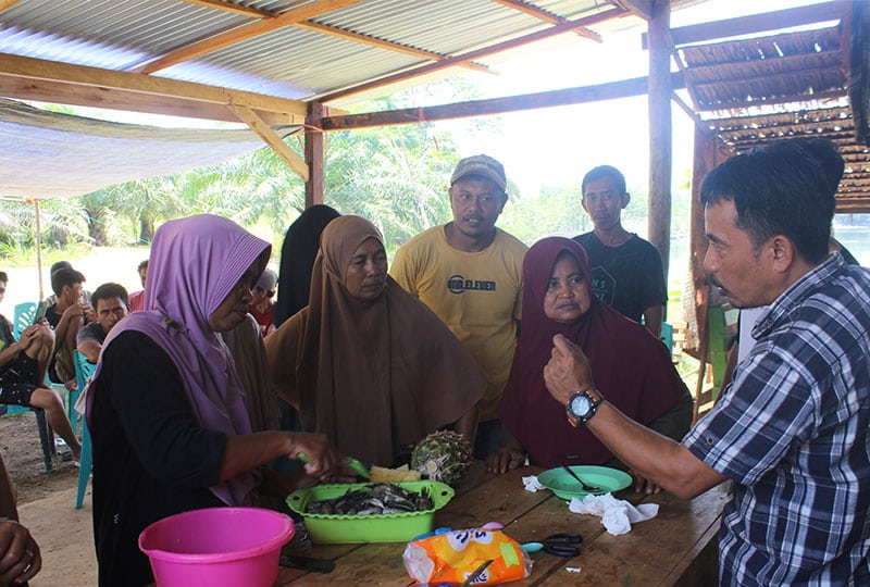 Three women listening to a man talk