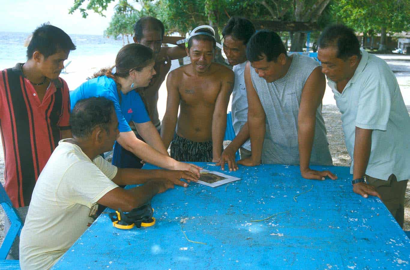 amanda vincent and a group of fishers standing over a blue table