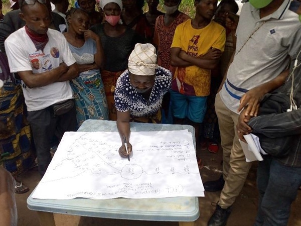 a person drawing on a map surrounded by others