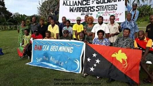 A group of people holding anti-deep-sea-mining banners