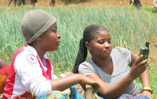 two people sitting in a field using a GPS