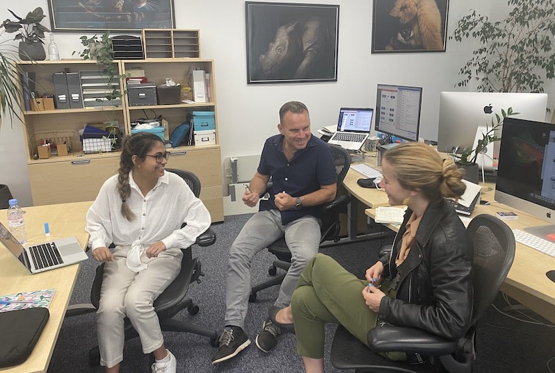 Three people laughing in an office.