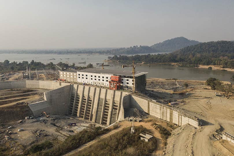 A large concrete hydropower dam blocking a wide river