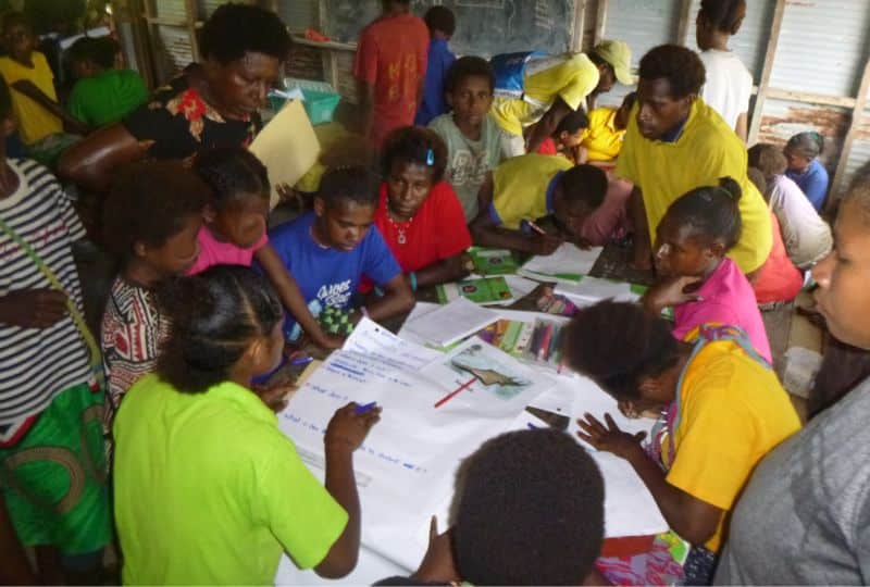 A group of people poring over maps and papers.