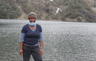 Miriam Supuma standing in front of a lake, mountain in the background