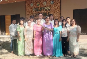 A group of people, one of them holding a small crocodile