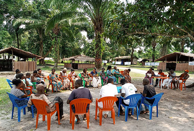 A community sat in colourful chairs gathered to discuss 