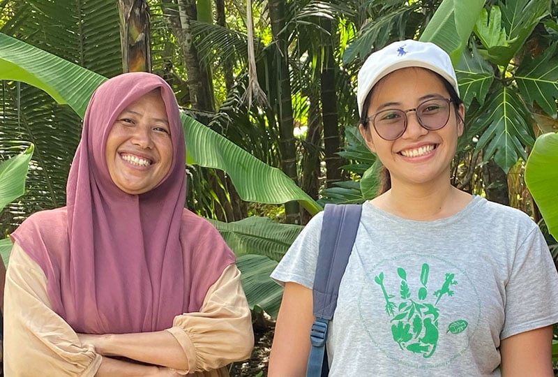 Asnim Alyoihana Lanusi (left) and Sheherazade (right) smile in front of a leafy background.