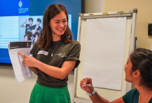 Smiling person points out document to person in workshop