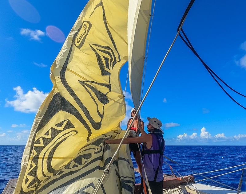 two people in a small boat sailing on the ocean