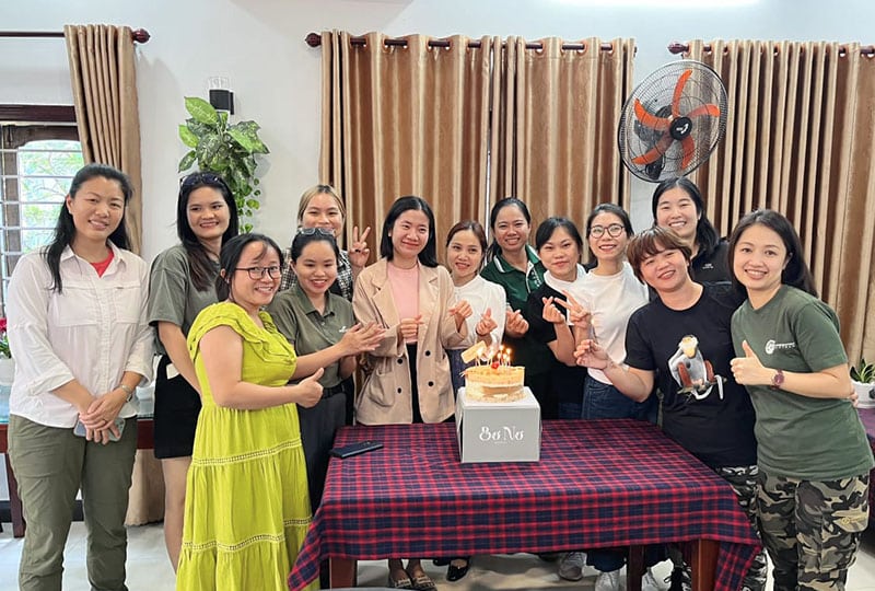A group of women celebrate with cake on a table