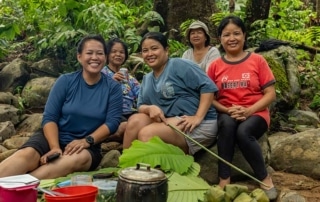 five women sitting and smiling.