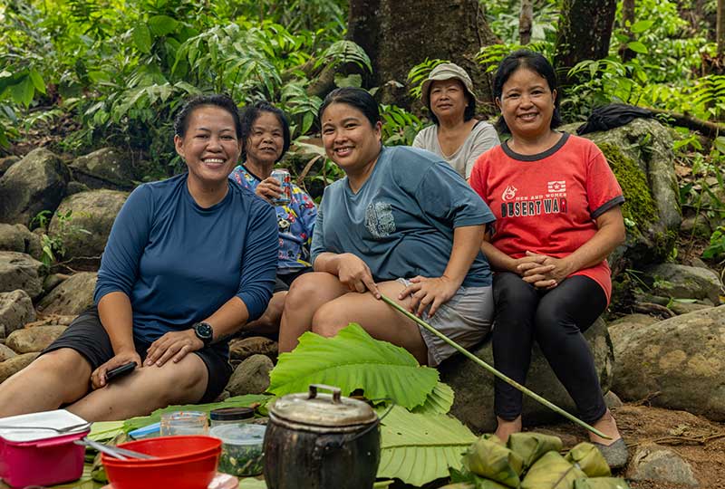 five women sitting and smiling.