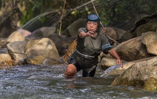 Salina casting a fishing net in the Terian river