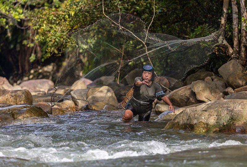 Salina casting a fishing net in the Terian river
