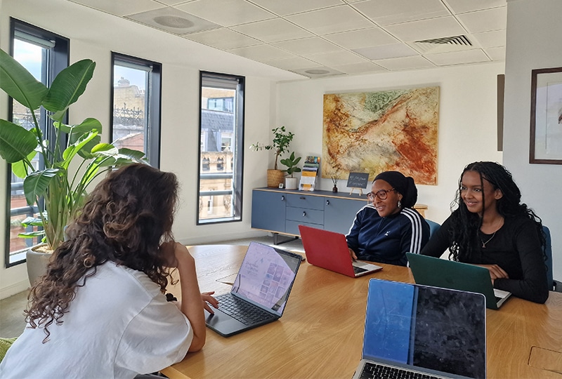 Three people sitting around a boardroom table