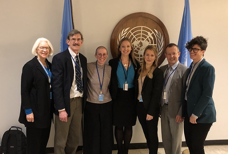 Seven people standing next to UN sign
