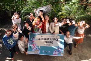 group of people posing for a photo with a banner that says Language Justice Training