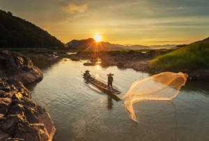 Fisherman fishing on the Mekong river during sunrise.