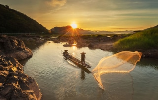 Fisherman fishing on the Mekong river during sunrise.