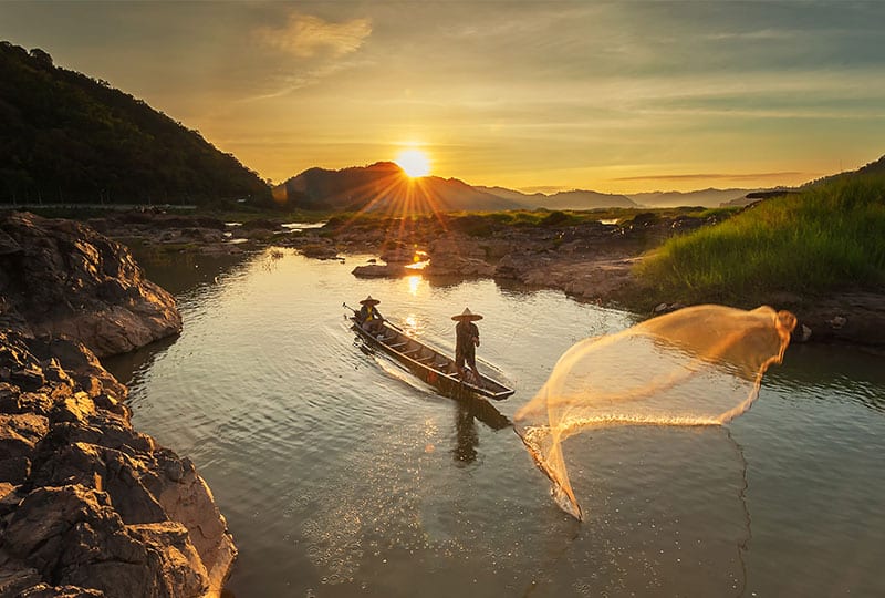 Fisherman fishing on the Mekong river during sunrise.