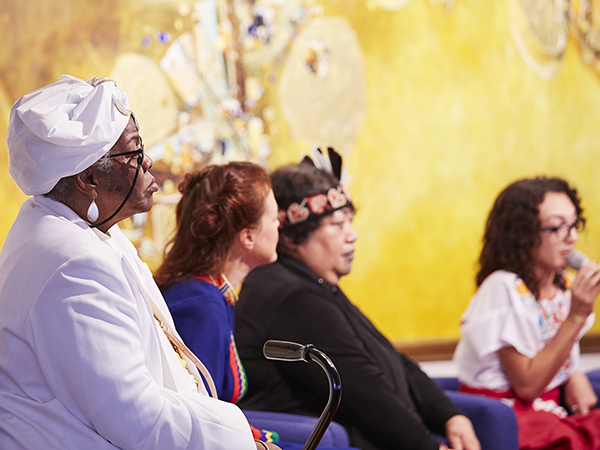 Four women sit on a stage at a panel discussion