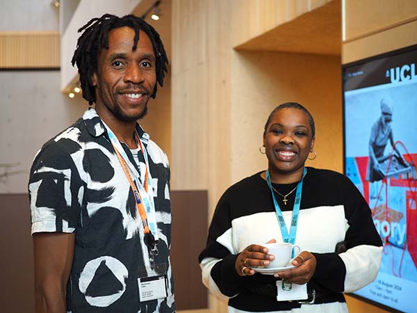 A man and a woman stand together smiling at an event held at UCL, London